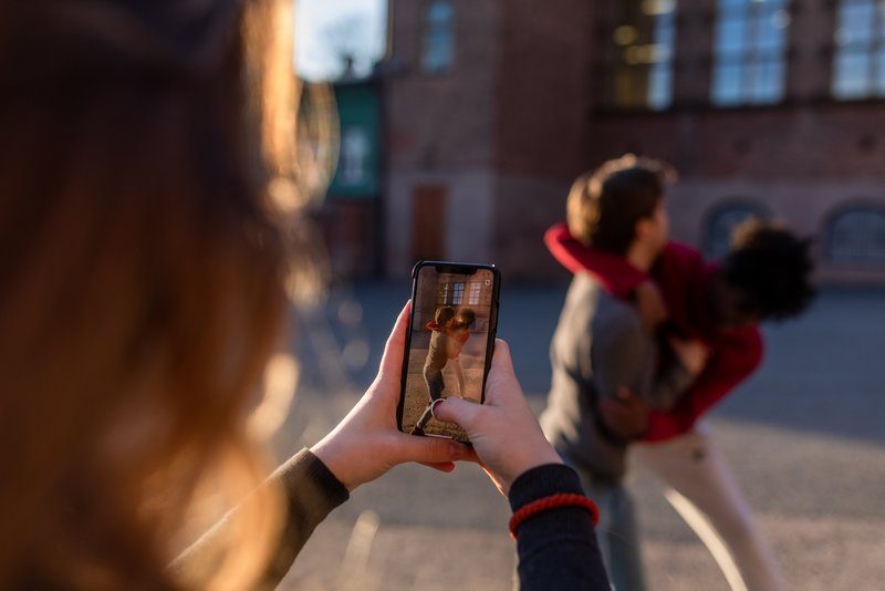 To gutter sloss, jente filmer med mobilen